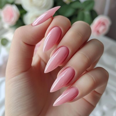 woman's hand holding pink nails.